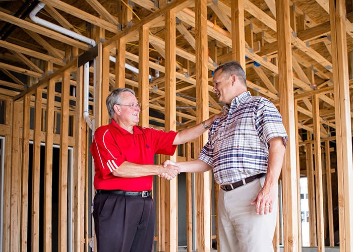 Sales Rep with Builder Inside Framed House